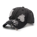 Dettaglio cappello da baseball in denim nero con spilla di sicurezza e ciondolo croce - Taglia unica / Nero
