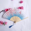 Bamboo folding fan featuring pink cherry blossoms and a blue tassel on white surface - Blue-White Gradient Cherry Blossom Style (Women's Hand Fan - 63)