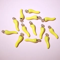 Top-down view of yellow enamel chili charms for DIY jewelry making on a pastel background - Yellow