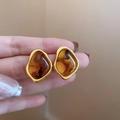 French vintage gold-framed resin earrings in amber brown held by a hand - 28# Silver Pin Gold Brown Oval Gold Plated