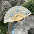 Beige silk folding fan with blue mountain embroidery on bamboo ribs with tassel - Landscape Painting