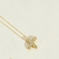 Elegant gold plated letter X necklace with sparkling cubic zirconia on cream background - Letter X