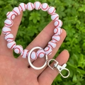 Detailed close-up of a white wooden baseball bead bracelet keychain with metal clasp - White Baseball