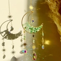 Detail of moon suncatcher with green crystals casting rainbow light on a beige wall - Aventurine Moon Wind Chime