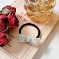 Elastic hair tie featuring a light blue and pink textured resin bow on a vintage book - Hair Tie / Blue & Pink