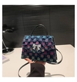 Detail der Karo-Denim-Handtasche mit Fransen und Silber-Schleife auf minimalistischem Tisch - Plaid Style 2