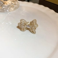 Detail shot of a golden bow ring with pave-set rhinestones and an adjustable open band - Gold Bowknot Pavé Rhinestone Style