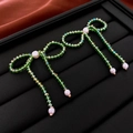 Macro shot of green beaded bow earrings with white pearls on a black jewelry stand - Green Beaded Bowknot Style (8#)