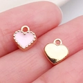 Pink enamel and gold heart charms pendants held on finger to show compact size - Pink Small Heart (18017)