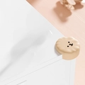 Beige bear-shaped silicone corner protector installed on a white table corner - Poodle-Apricot