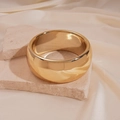 Primer plano de brazalete ancho de metal dorado sobre piedra con fondo de seda - Dorado irregular