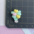 Vue macro de breloques en résine de ballons en cœur avec gravure love sur tapis de coupe - Ballon Vert