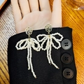 Elegantes pendientes de lazo de camelia con perlas sobre fondo de manga negra - Estilo de Borla con Lazo de Camelia (E6078-2)