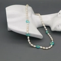 Detail van zoetwaterparelketting met blauwe bloemen op een buste display voor sieraden - Blauw