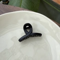 Close-up of matte black 5.5cm hair claw clip on a ceramic plate with natural decor - 5.5cm Butterfly Buckle / Matte Black