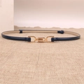 Detalle de un cinturón fino de charol azul marino con hebilla de metal dorado elegante - Negro