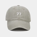 Detailansicht der weißen 77er-Stickerei auf einer gewaschenen Vintage-Baseballkappe - Graugrün