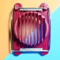 Coupe-œuf rouge en plastique avec fils métalliques sur fond bicolore orange et bleu - Bordeaux