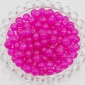 Macro view of translucent magenta glass beads with pre-drilled holes in a clear glass bowl - 4mm / Purplish Red