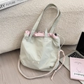 Dettaglio borsa shopper in nylon verde con coulisse rosa e tracolla in tessuto intrecciato - Stile Coulisse a Contrasto di Colore / Grigio chiaro