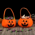 Two orange felt pumpkin candy bags with black face silhouettes and wide handles - Soft Material Pumpkin Bag