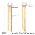 Détail des boucles d'oreilles à pompons en acier doré avec perles de coquillage - Doré