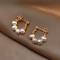 Dettaglio di orecchini con perle d'acqua dolce barocche su sfondo di raso scuro - Oro (Perla Barocca Naturale)