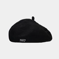 Close-up of the detailed 1987 white embroidery on a black wool beret painter hat - One Size / Black