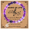 Detailed macro view of an 8mm purple natural stone music bracelet with a musical note charm - Purple Stripe Agate