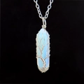 Macro detail of Tree of Life pendant with silver wire wrapped around white opal stone - Opal