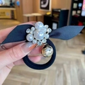 Détail d'un chouchou élégant en perles avec nœud en satin et accents strass - Chouchou Nœud Perle Blanche