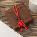 Retro skeleton skull keychain with red paracord weaving and bronze helmet on wood background - Fluorescent Red