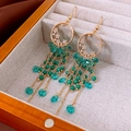 Macro detail of bohemian tassel earrings with emerald beads and crystal drops - Gold-Blue-Purple Hook