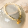 Gros plan de perles de citrine jaune et pendentif gourde dorée sur de la céramique - Jaune (Avec Boîte-Cadeau Exquise)