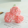 Handcrafted pink crochet carnation bouquet with three knitted flowers on magazine background - Carnation Gradient Pink