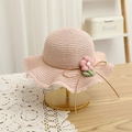 Close-up of pink straw sun hat for girls with floral decoration and wavy brim detail - Straw Hat Only / Pink