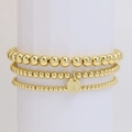 Set di tre bracciali con perline dorate e un ciondolo rotondo con lettera T - Lettera T