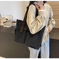 Detailansicht der schwarzen Canvas-Tragetasche mit Taschen, über der Schulter getragen - Schwarz