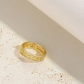 Detail of gold geometric hollow ring with sparkling stones on textured stone - Hollow Style (JZ0465-1)