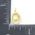 Golden Saturn pendant with white zircon ring, size 1.5cm shown on measurement scale - Planet