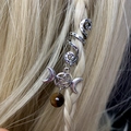 Close-up of silver triple moon and pentagram hair charm with a brown bead on golden braids - Triple Moon Pentagram