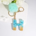 Letter H resin keychain with blue shell pieces and mint green pompom charm - Letter H