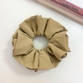 Close-up of khaki faux leather scrunchie with matte texture on white surface - Brown (Three-layer)