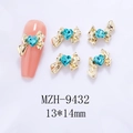 Macro detail of golden bow nail art charms with heart-shaped blue gems on pink fake nails - Gold Bowknot Lake Blue Heart(9432)