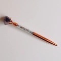 Macro detail of rose gold metal pen featuring colorful natural crystal stone filling - Fluorite