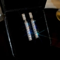 Close-up of sparkling zircon butterfly tassel earrings in a black luxury jewelry box - Silver