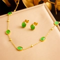 Set di gioielli in acciaio dorato con pietre verde smeraldo ovali su sfondo di seta - Set da 2 Pezzi Collana Orecchini (N2903)