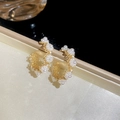 Detalle macro de elegantes pendientes dorados en C con motivos florales de perlas - Pendientes de Racimo de Flores de Perlas en Forma de C - Dorado Blanco
