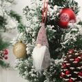 Close-up of a festive Christmas gnome hanging on a snowy tree with heart knit cap - Style H