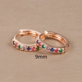 Macro detail of 9mm rose gold huggie earrings with a row of rainbow colored gemstones - 9mm / Rose Gold